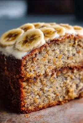 A slice of moist banana bread cake topped with walnuts and fresh banana slices.