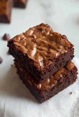 Delicious brown butter brownies topped with chocolate chips on a wooden table.