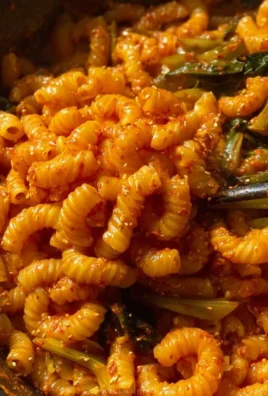 Bowl of creamy gochujang pasta with fresh herbs and chili flakes