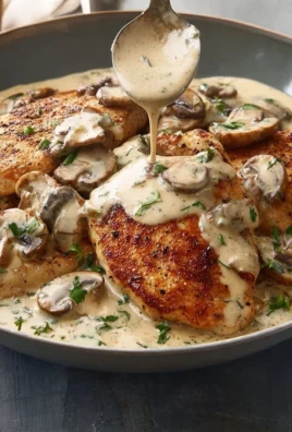 Creamy mushroom chicken dish served with herbs and fresh vegetables