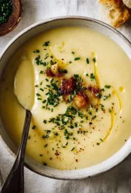 Bowl of creamy potato leek soup garnished with fresh herbs