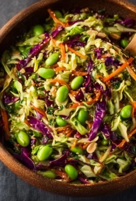 Crunchy cabbage salad with edamame and sesame ginger dressing served in a bowl.