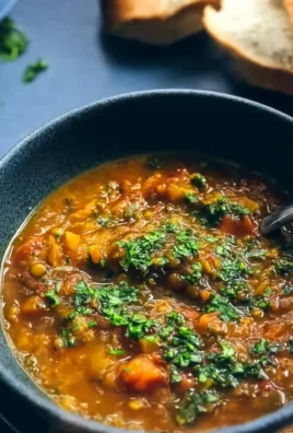 Bowl of Damn Good Vegan Lentil Soup garnished with herbs