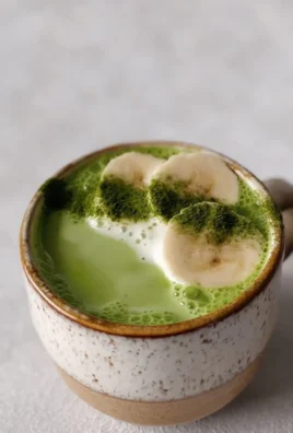 Easy Banana Cream Matcha Latte topped with whipped cream and banana slices