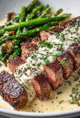Garlic Butter Steak topped with creamy Parmesan sauce served on a plate.