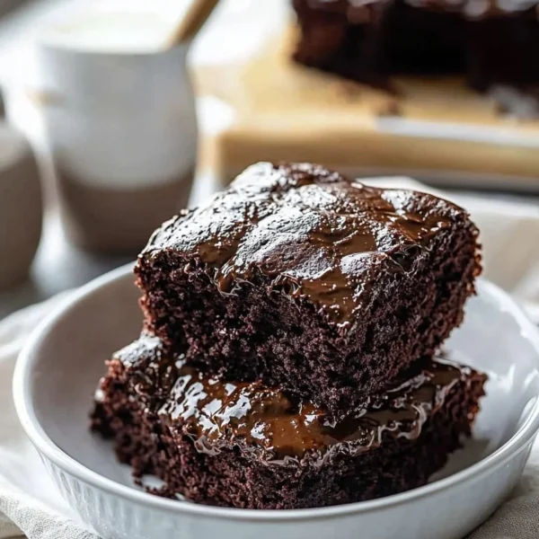 Delicious Hot Fudge Cake drizzled with chocolate sauce and topped with whipped cream.