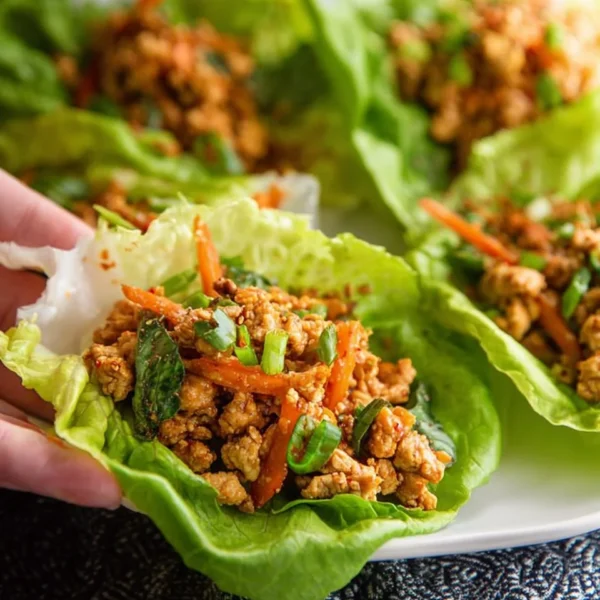 Plate of Low Carb Thai Chicken Lettuce Wraps with fresh vegetables and sauce