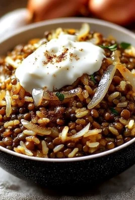 Bowl of Mujadara with lentils, rice, and caramelized onions served on a rustic table.