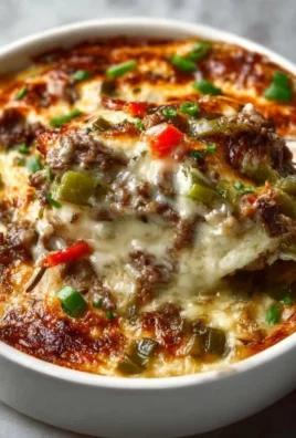 Delicious Philly Cheesesteak Casserole topped with melted cheese and diced peppers