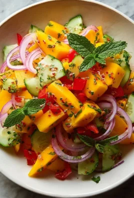 Delicious mango salad topped with fresh lime dressing on a plate