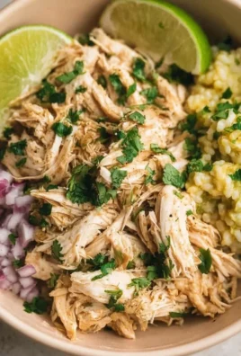 Delicious shredded slow cooker cilantro lime chicken served in a bowl with fresh toppings.