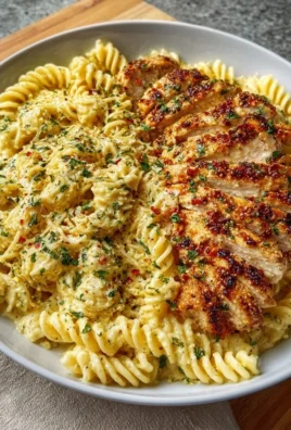 Creamy garlic parmesan chicken pasta served in a bowl, garnished with parsley.