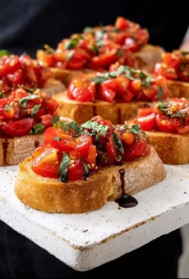 Delicious tomato bruschetta topped with fresh basil and balsamic glaze.