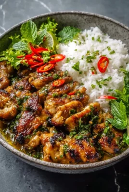 A plate of Vietnamese Lemongrass Chicken garnished with fresh herbs and served with rice.