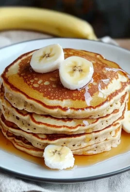 Fluffy 3 ingredient banana pancakes served on a plate with syrup and berries.