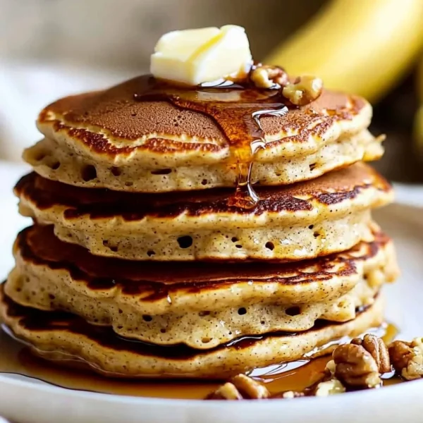 Delicious banana bread pancakes served with syrup and bananas on top