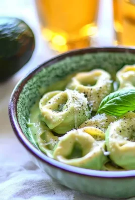 Creamy California avocado tortellini served with fresh herbs and cherry tomatoes.