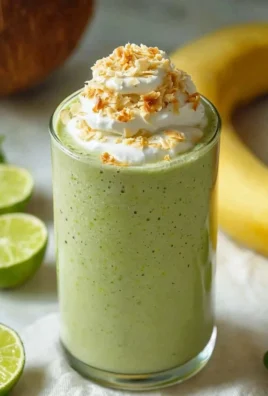 Creamy coconut key lime pie smoothie topped with lime zest and coconut flakes