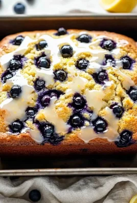 Slice of lemon blueberry bread drizzled with lemon glaze on a plate