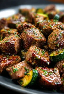 Sizzling garlic butter steak bites served on a plate with herbs