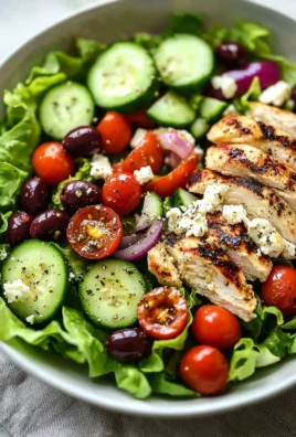 Healthy Greek salad with chicken, fresh vegetables, and feta cheese on a plate