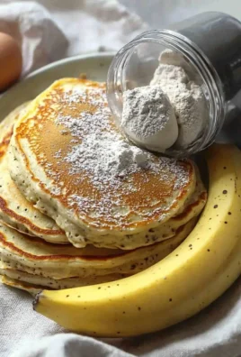 Plate of fluffy high protein pancakes topped with fresh fruits and syrup
