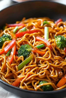 Bowl of Lo Mein noodles topped with fresh vegetables and savory sauce