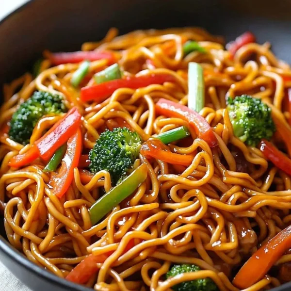 Bowl of Lo Mein noodles topped with fresh vegetables and savory sauce