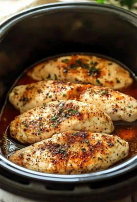 Tender slow cooker chicken breasts ready to serve with herbs and spices.