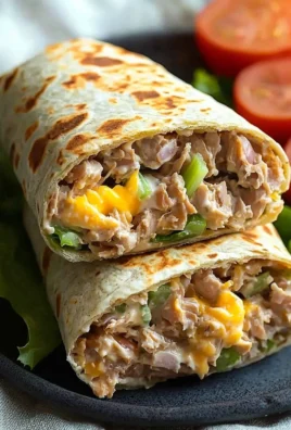 Tuna melt wrap with melted cheese and fresh ingredients on a plate.