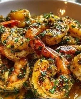 Sizzling garlic butter shrimp in a skillet, garnished with fresh herbs.