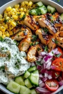 Delicious Greek Chicken Bowl topped with fresh vegetables and tzatziki sauce