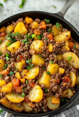 Plate of ground beef and potatoes dish garnished with herbs