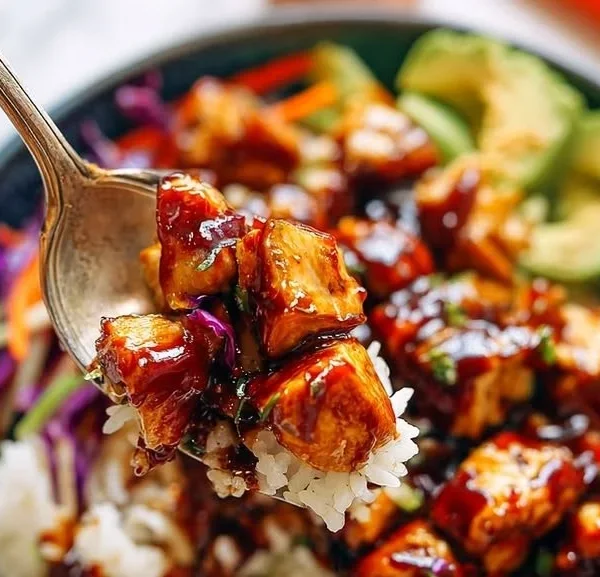 Delicious homemade BBQ Chicken Rice Bowl topped with fresh vegetables