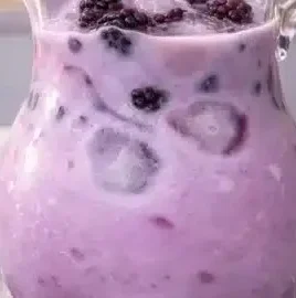 Homemade blackberry coconut drink served in a glass with fresh berries