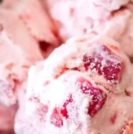Bowl of homemade strawberry ice cream topped with fresh strawberries