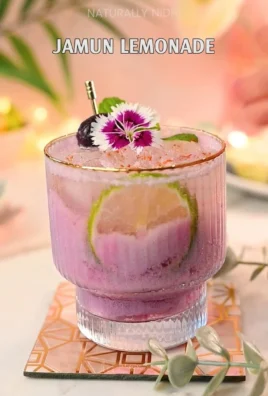 Refreshing glass of Jamun Lemonade with fresh jamun and lemon slices
