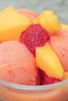Delicious Mango Strawberry Sorbet served in a bowl with fresh fruits