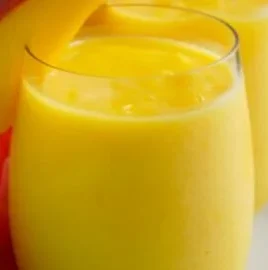 Delicious Mango Smoothie served in a glass garnished with fresh fruit.