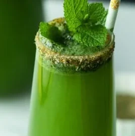 Mint margarita served in a glass with fresh mint leaves and lime.