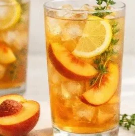 A refreshing glass of Peach Thyme Iced Tea garnished with fresh thyme and peach slices.