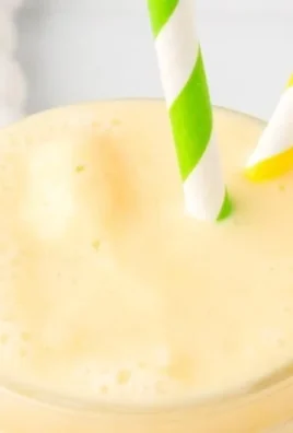 Refreshing Pineapple Orange Smoothie in a glass with tropical fruits