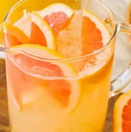 Refreshing Big Batch Palomas cocktail served in a glass with garnishes