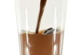 A refreshing glass of chocolate coconut water garnished with coconut slices.