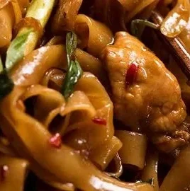 Plate of colorful drunken noodles with vegetables and shrimp