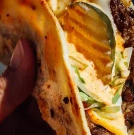 Delicious smash burger tacos served on a plate with toppings