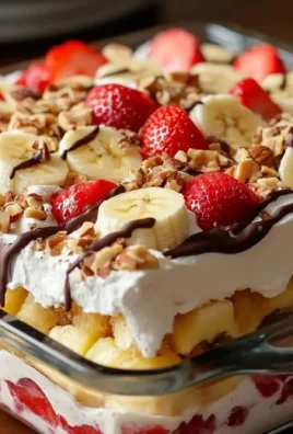 No-bake banana split cake topped with whipped cream and cherries