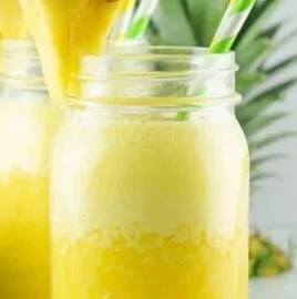 A refreshing glass of Pineapple Aqua Fresca with fresh pineapple slices.