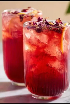 Refreshing glass of Rose Hibiscus Iced Tea with floral garnishes