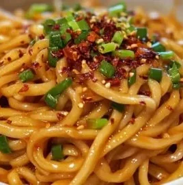 Delicious bowl of spicy garlic chili noodles with vibrant toppings